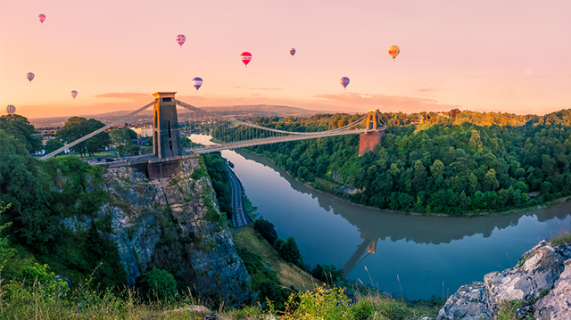 Hot air balloons over Clifton Suspension Bridge at sunrise
